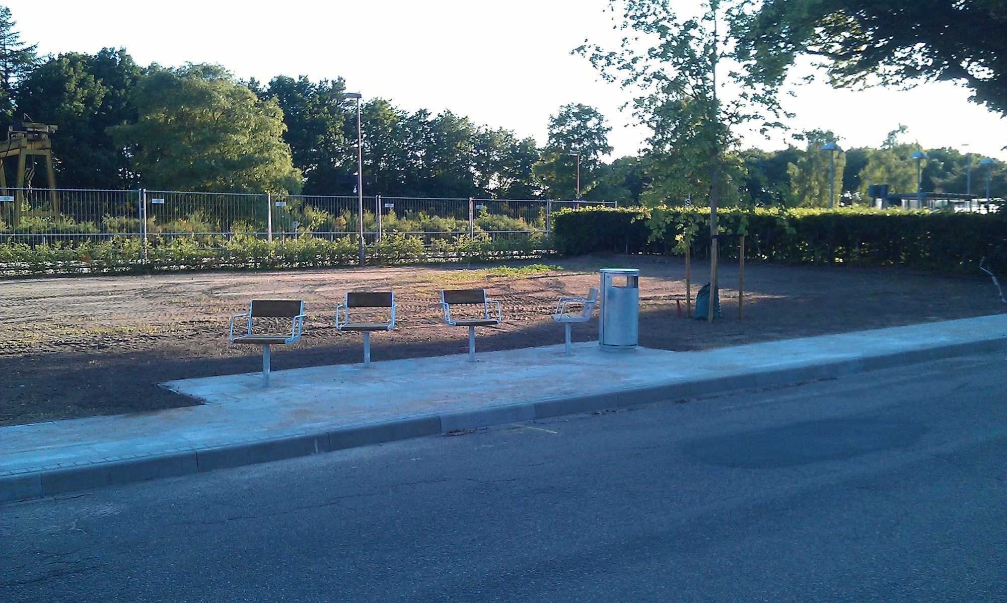 Åben plads med opholdsmøbler og græs