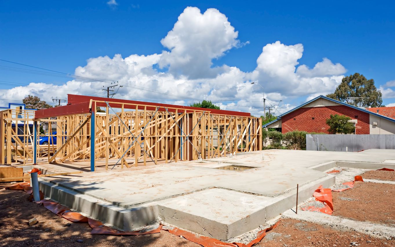 Påbegyndt bygning. Sokkel og træskelet.