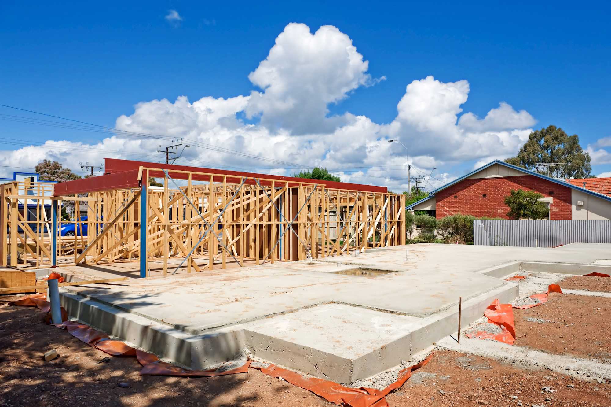 Påbegyndt bygning. Sokkel og træskelet.