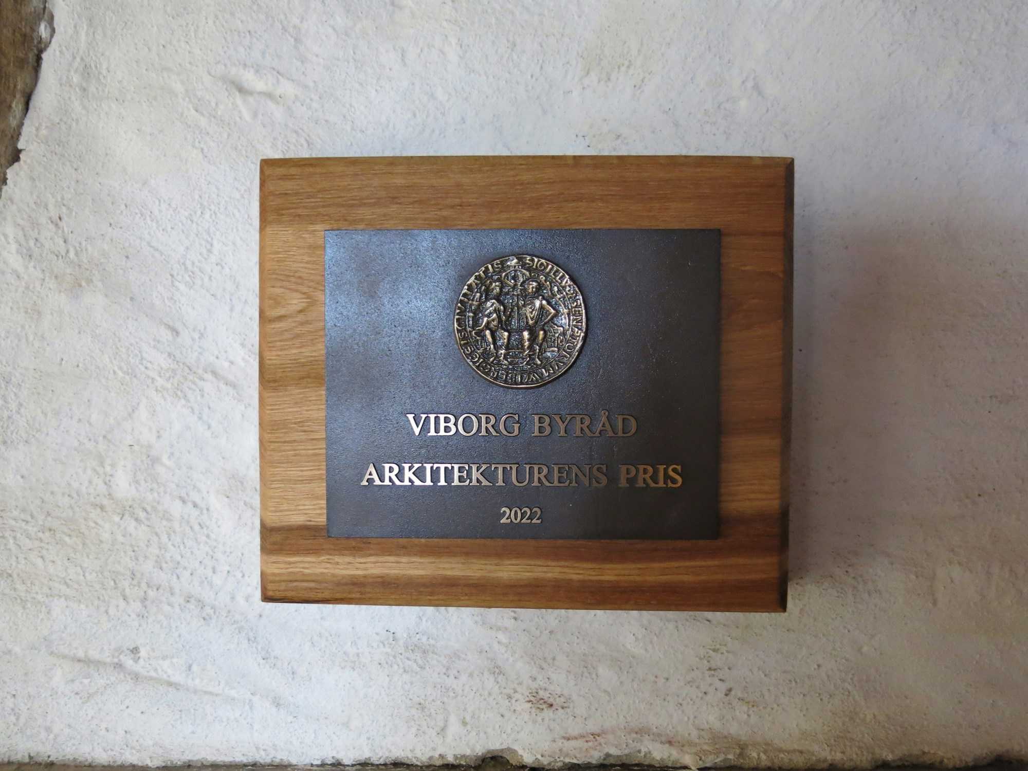 Nærbillede af plaketten, der blev givet for Arkitekturens Pris i 2022, hænger i Hald Laden