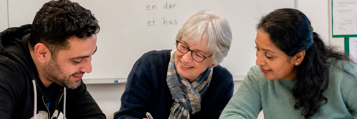 En underviser på sprogskole hjælper to elever