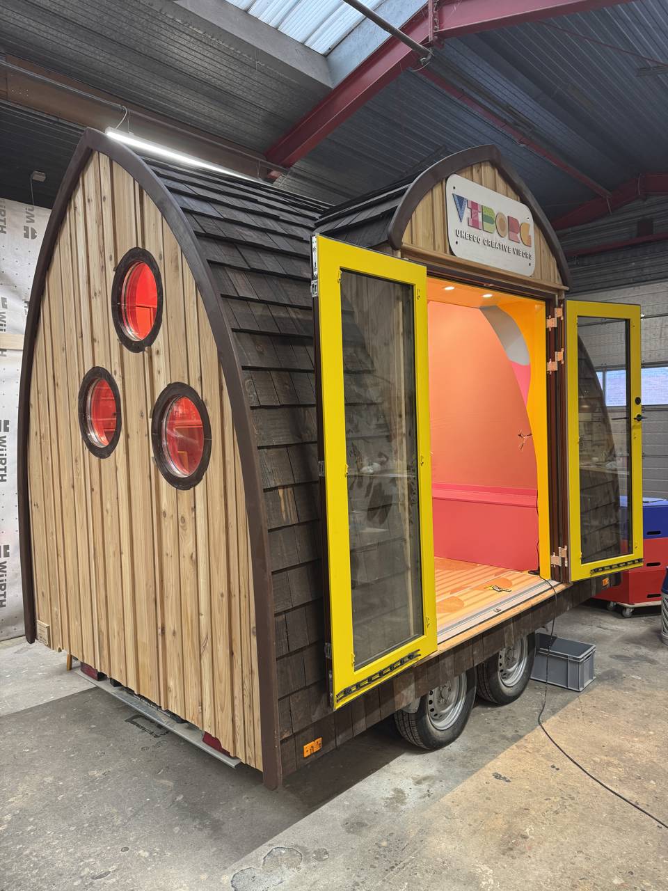 Aktivitetshuset set udefra, hvor det nærmest ligner en lille hytte i en skov.