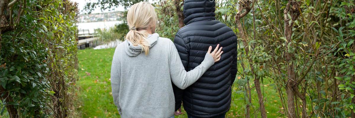 Kvinde holder hånden på ryggen af en mand